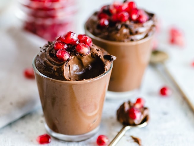 Cup of chocolate mousse topped with fruit.